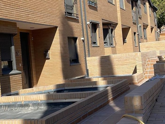 Jardineras y muretes de caravista frente a las viviendas