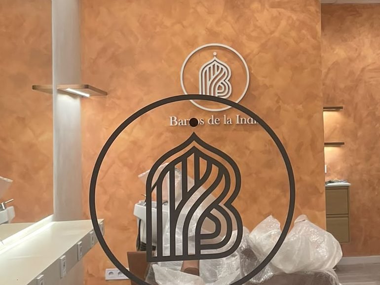 Detalle del local visto a través del escaparate, con la pared de estuco y las baldas iluminadas